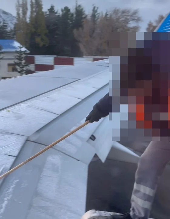 Así intentaban los operarios del aeropuerto quitar el hielo de las alas del avión (Captura video)